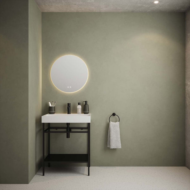 Bathroom with round mirror, sink, and towel on a green wall