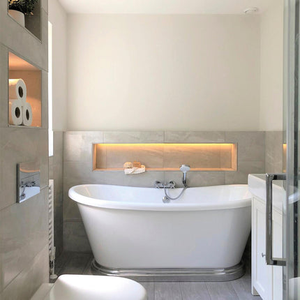 Modern bathroom with a freestanding bathtub, toilet, and shelves.