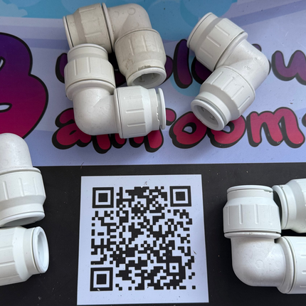 White plastic pipe fittings on a black and blue background with a QR code.