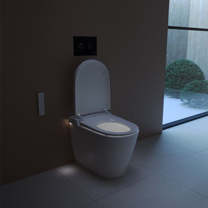 Modern toilet in a dimly lit bathroom with a view of greenery outside.