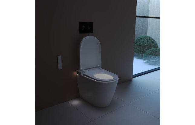 Modern toilet in a dimly lit bathroom with a view of greenery outside.