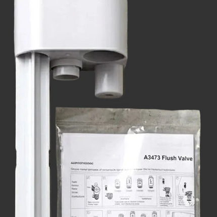 White plastic A1347 flush valve shown upright next to its sealed instruction manual on a dark gray background.