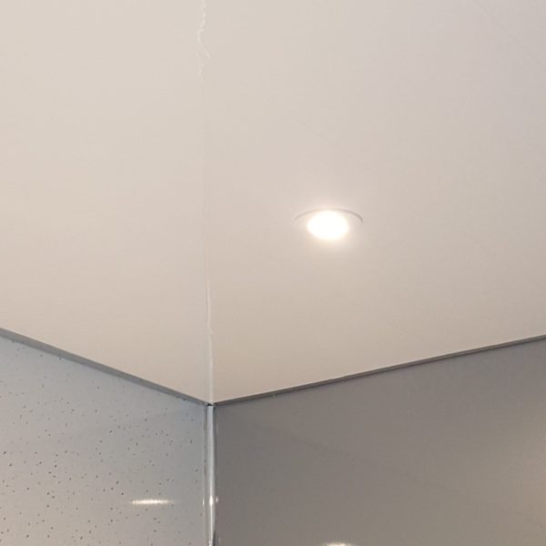 Ceiling light fixture in a room with white ceiling and gray walls.